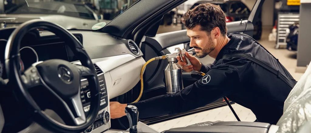 Mann reinigt Innenraum eines Mercedes-Benz